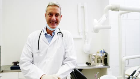 smiling dentist standing in dental clinic