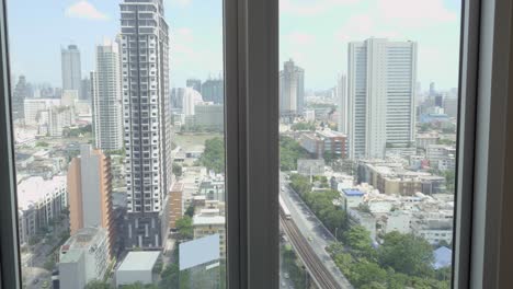 Mujer-Bañándose-Y-Haciendo-Selfie-Con-Vista-Celular-De-Bangkok-En-La-Ventana