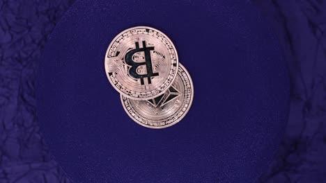 bitcoin and ethereum coins on purple background. - high angle shot