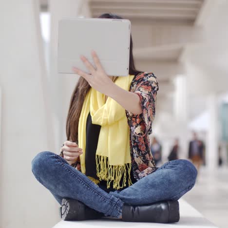 smiling woman waving at her tablet computer