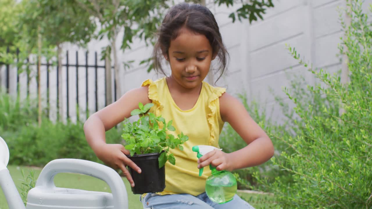 행복한 히스패닉 소녀가 정원에서  ⁇ 비에 꽃을 물고 있습니다.