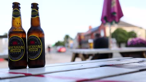 two beer bottles on a table outdoors