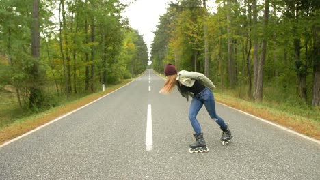 niña con patines en línea en la calle, haciendo una parada de manos