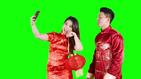 asian couple taking selfie photo with lanterns