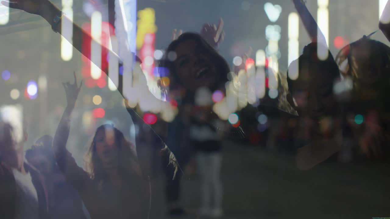 Friends dancing and cheering in entertainment district, showing neon signs and light trails