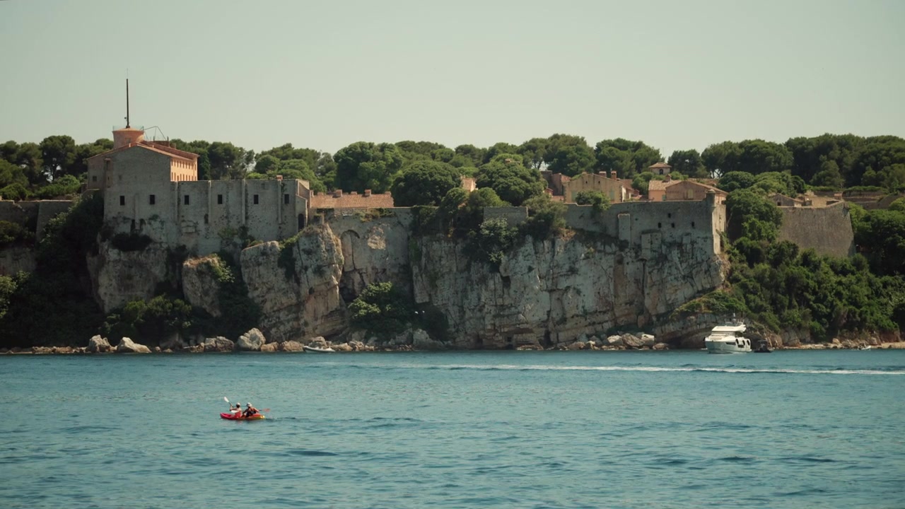 Fortezza Fort Royal sull'isola di Sainte-Marguerite, Cannes, Isole di Lérins. Kayaker e uno yacht navigano sul Mar Mediterraneo