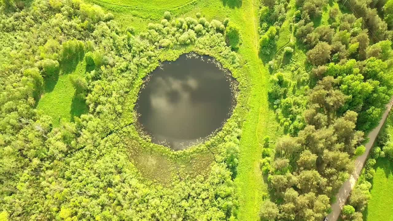 완벽하게 둥근 모양의 작은 호수 위에서 위에서 아래로 공중 비행.