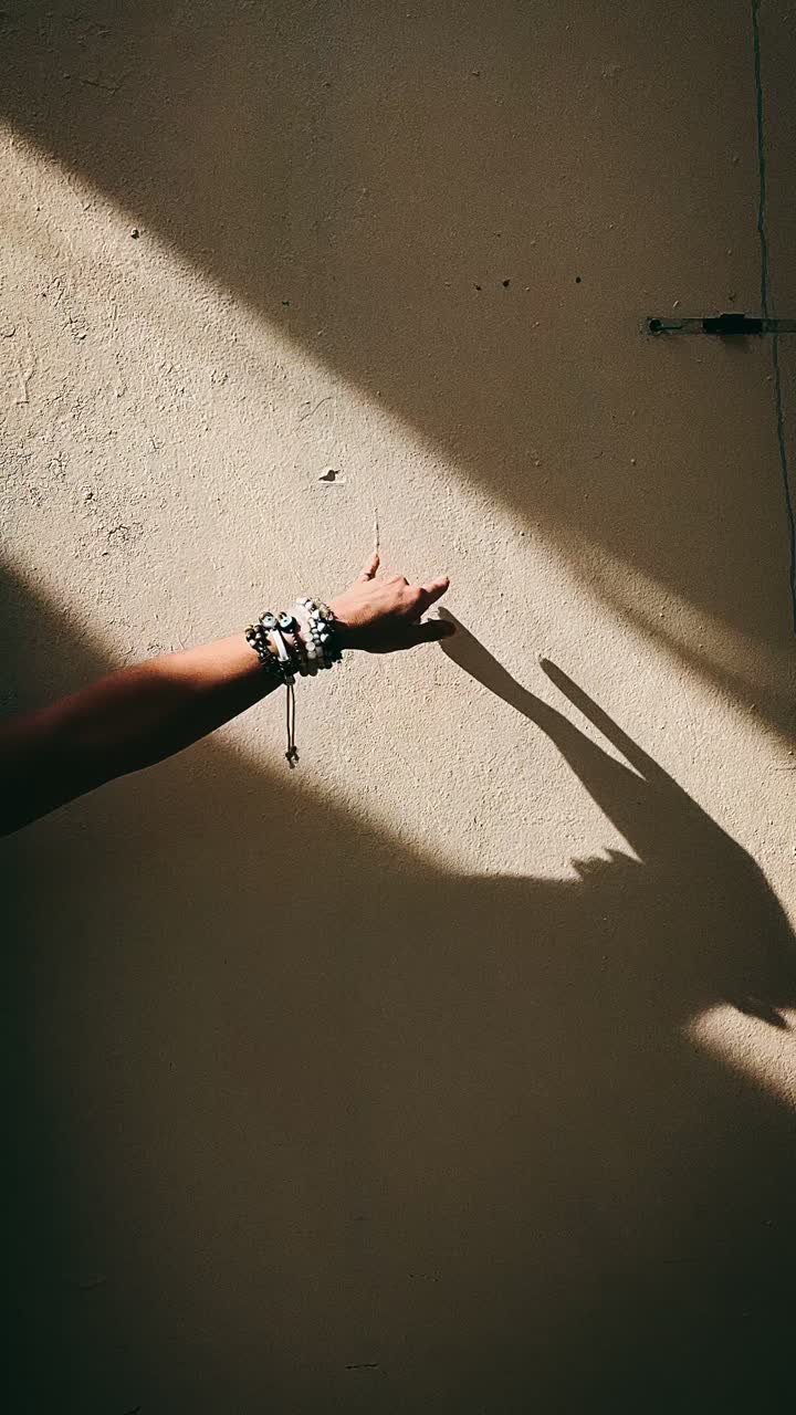 Hand and Shadow on a Beige Wall