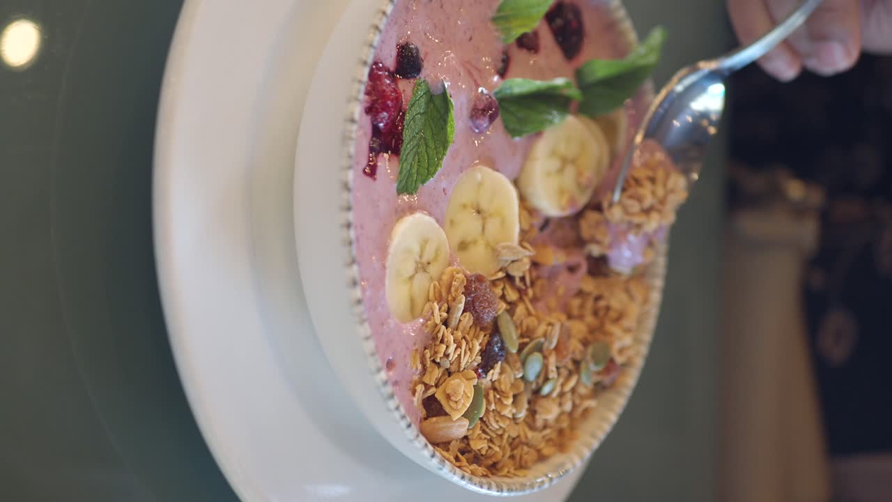 A delicious smoothie bowl with granola, fruit, and mint