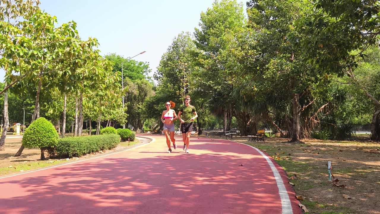Una pareja corriendo en un parque.