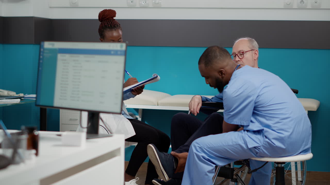 Medical professionals consulting with elderly patient in wheelchair