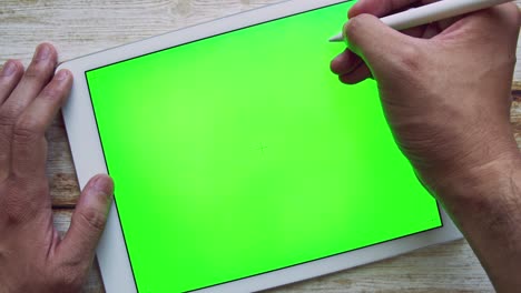 slowly zoom in man writing on tablet with green screen chroma key with pen