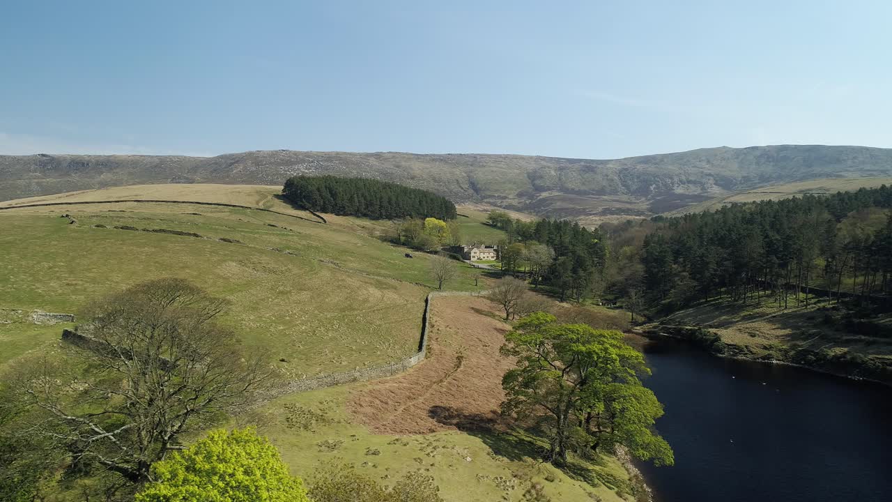 toma aérea panorámica sobre el agua del embalse de kinder que muestra una finca de fideicomiso nacional en la distancia ubicada en el valle de kinder scout