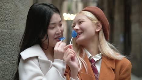 two women with lollipops on a street