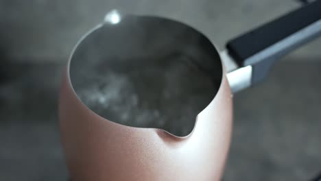 heating water in a rose gold turkish coffee pot