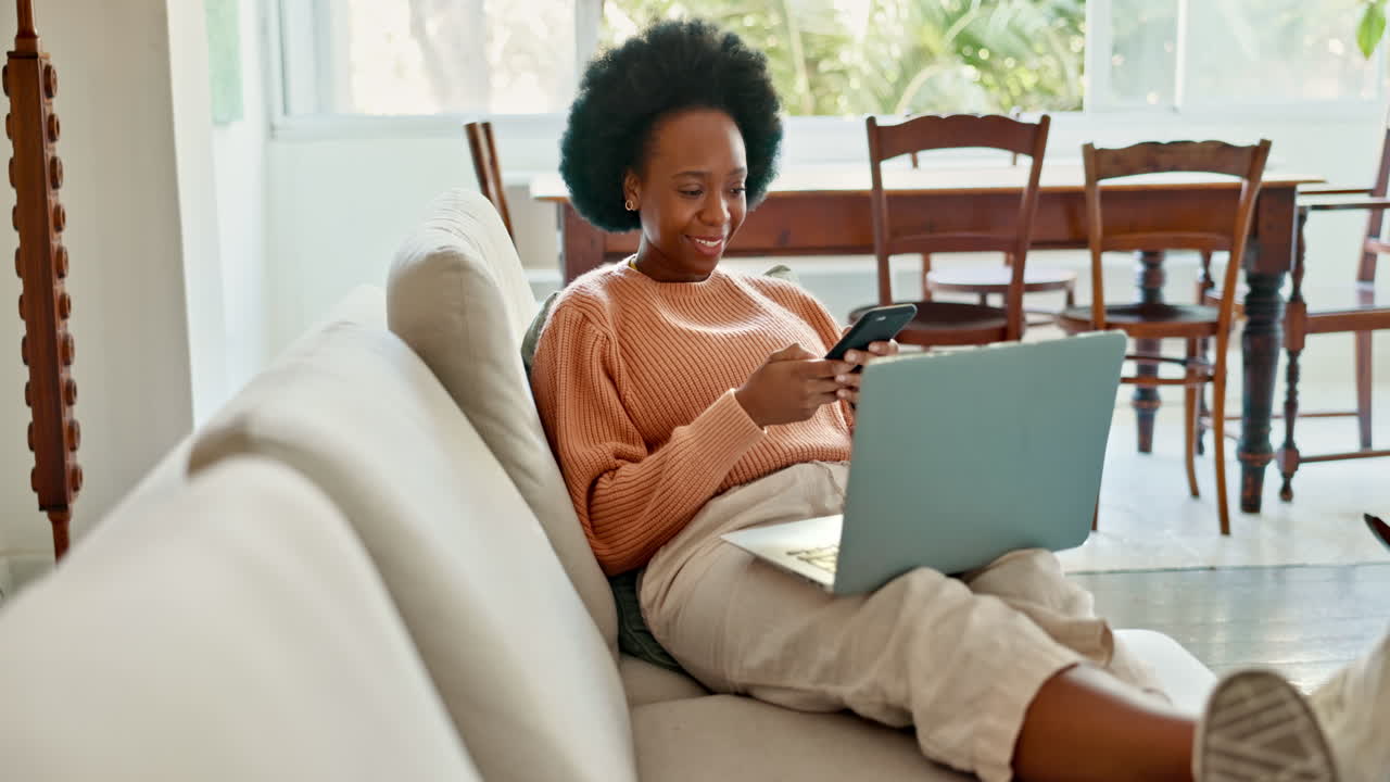African woman working on laptop on living room
