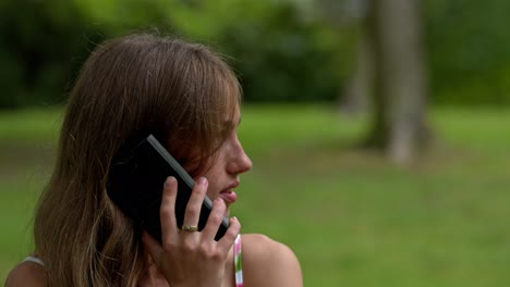 una mujer hablando por teléfono, en un lugar al aire libre