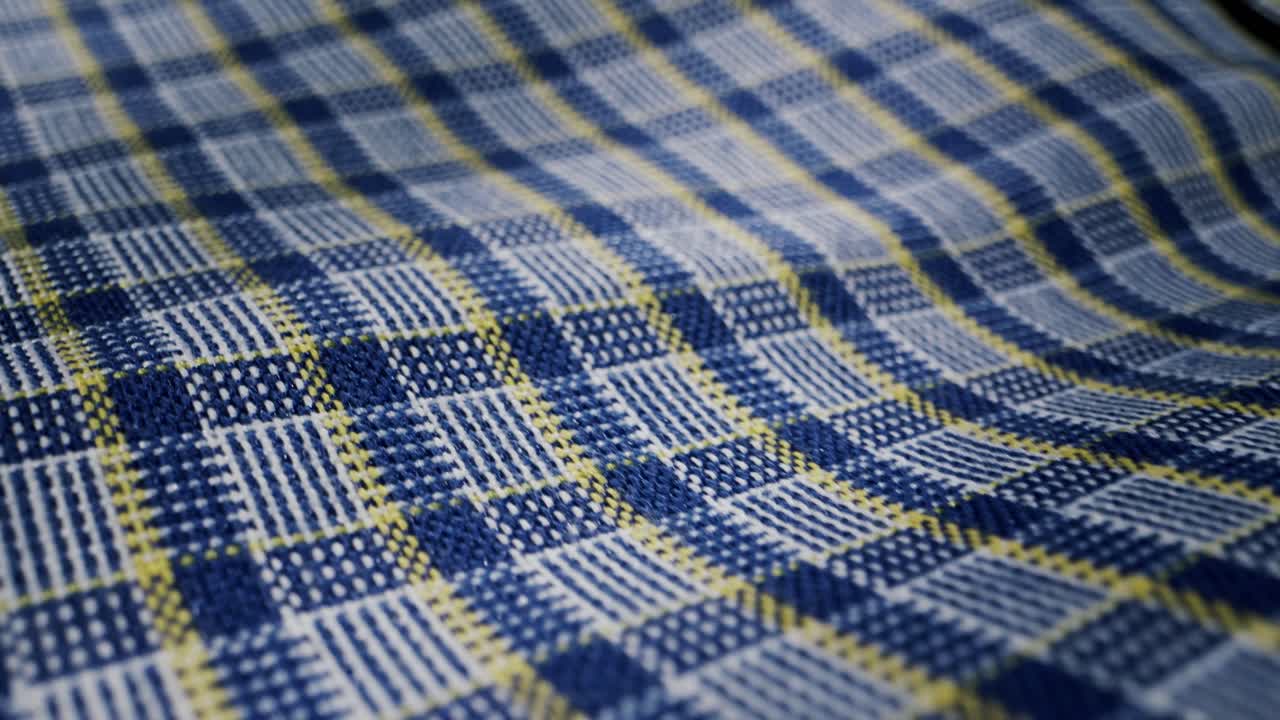 Here is a detailed view of a beautifully woven blue and yellow plaid fabric, showcasing an intricate, textured pattern