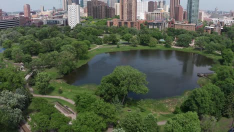 aerial tilting up shot of loring pond to reveal the minneapolis skyline in minnesota