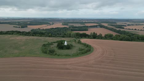 aerial orbit of farley mount monument, winchester, uk, surrounded by open fields and natural landscape