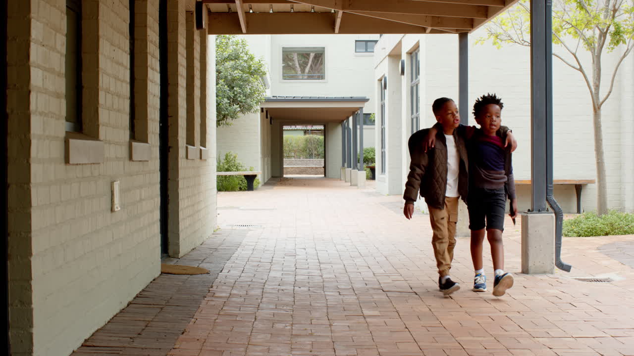 multiracial boys walking together at school, supporting each other with smiles, copy space