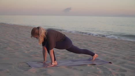 yoga teacher performing yoga moves on the beach