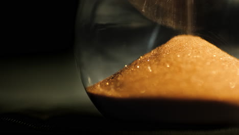 Schöne-Sanduhrdetail-Sandkörner-Fallen-In-Einem-Haufen-In-Die-Untere-Flasche