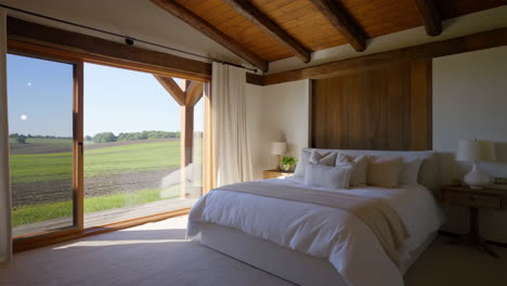 spacious bedroom with panoramic countryside view and wooden beams