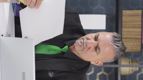 Vertical-video-of-Businessman-thinks-looking-at-documents.