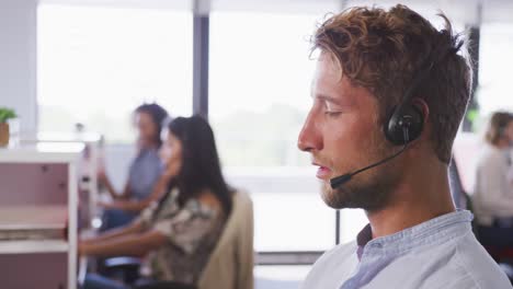 hombre de negocios profesional hablando por teléfono con auriculares en una oficina moderna en cámara lenta