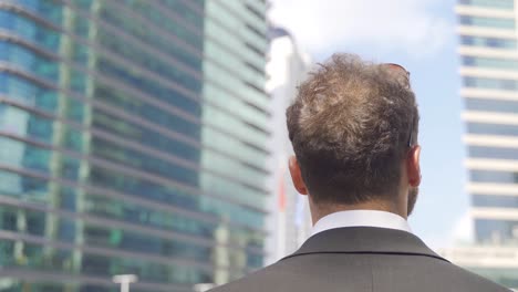 Businessman-near-high-rise-buildings.