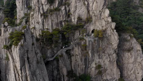 Personas-En-La-Pasarela-De-La-Montaña-Amarilla,-Provincia-De-Huangshan-Anhui,-China,-Bajando-La-Vista-Aérea