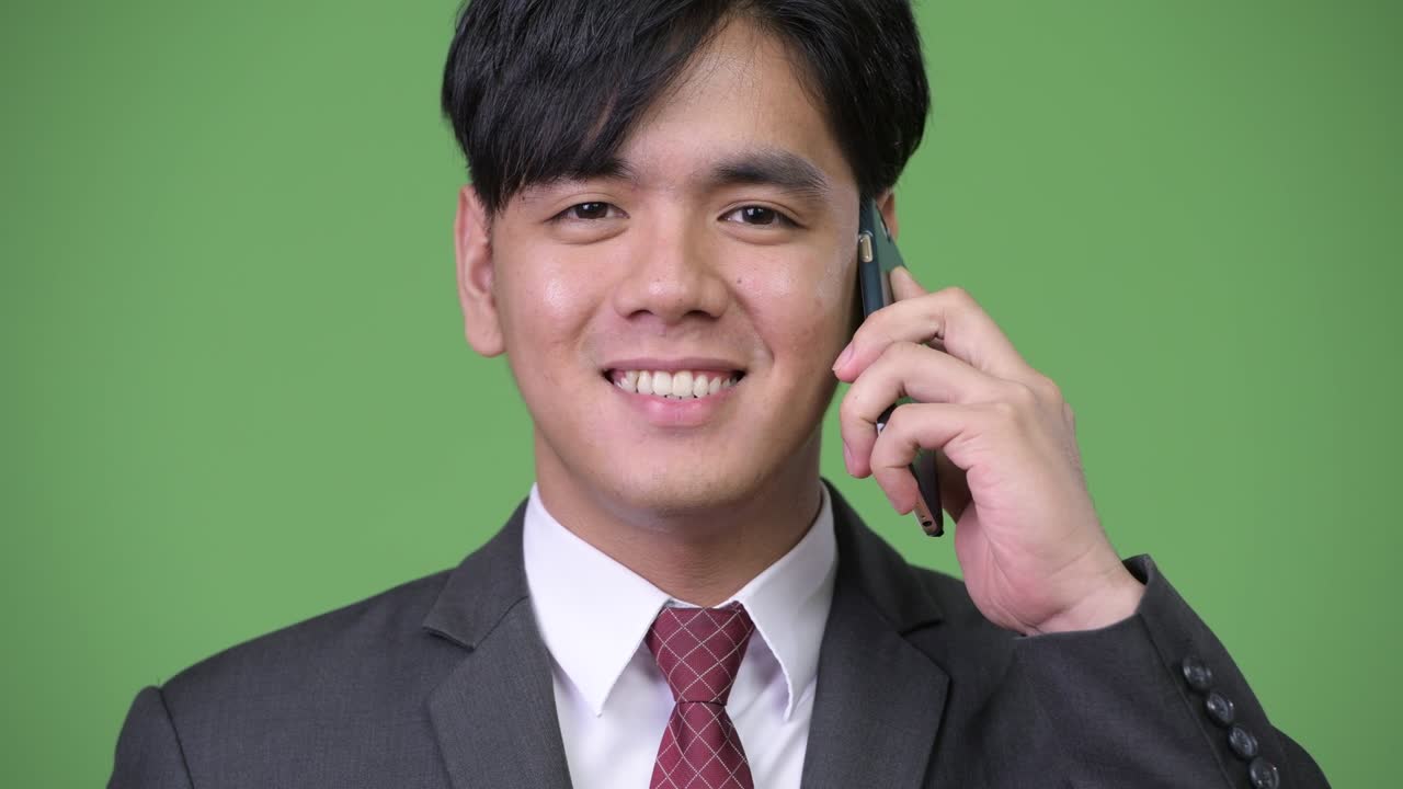 휴대전화를 사용하는 젊은 잘생긴 아시아 사업가