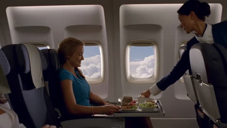 woman receives an in-flight meal on an airplane