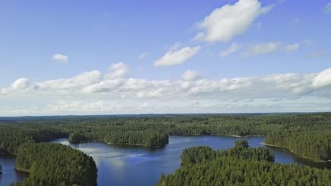 aerial footage of a finnish lake in summer, blue sky, heavy clouds and sun, revealing shot from top to bottom, carelia