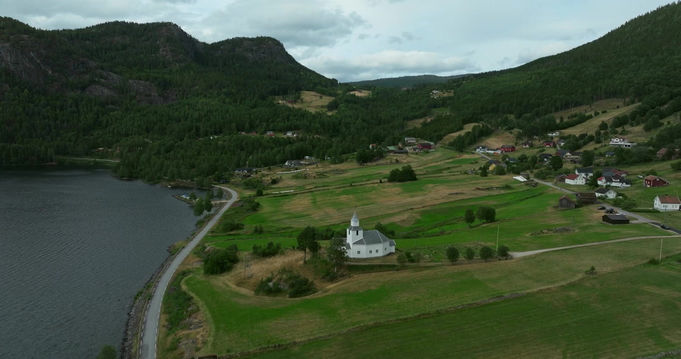 Flygvy över vit kyrka i Byglands landsbygdsdal i Norge.