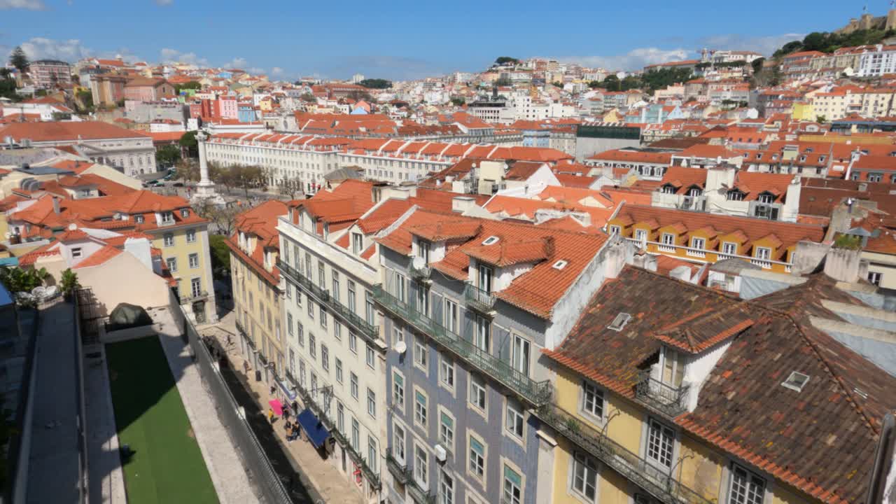 Splendida vista sopraelevata del centro storico di Lisbona che mostra i tradizionali tetti in terracotta arancione, facciate colorate e una densa architettura urbana sotto un cielo azzurro brillante