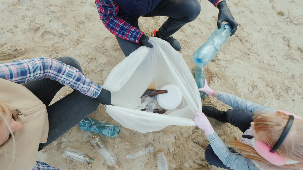 los voluntarios colocan la basura recolectada en la playa en una vista de paquete desde arriba
