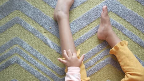 child's feet and legs on a yellow zigzag carpet