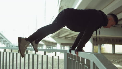 Sportler-Macht-Straddle-Planche-An-Bars-Im-Freien