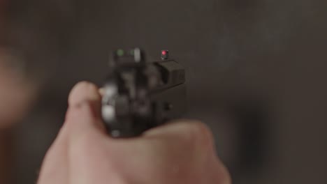 overshoulder of 9mm pistol being fired and a casing being ejected in slow motion