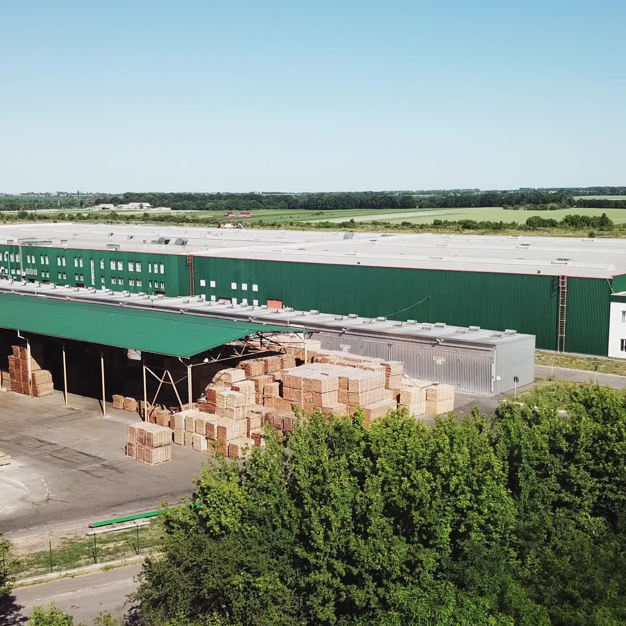a factory for manufacturing a parquet board is in the middle of the field. Aerial view