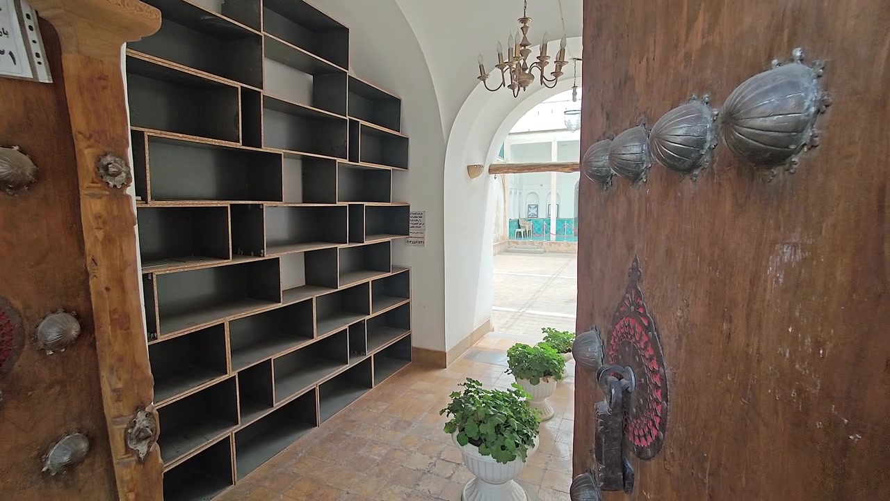 Porta in legno tradizionale che si apre su un cortile interno moderno