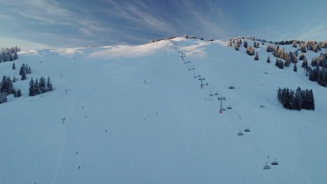 ski lift and skiers on the mountain ski resort in saalbach-hinterglemm, austria - aerial drone shot