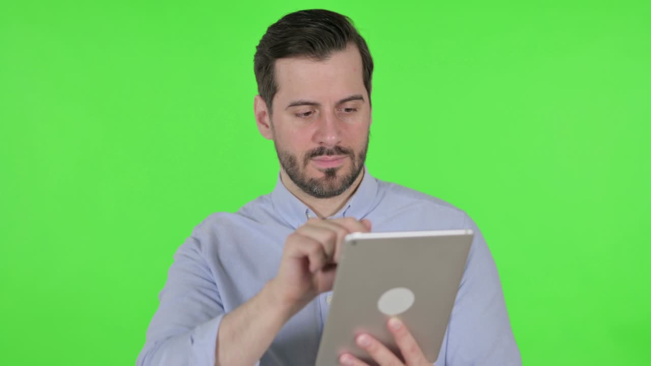 hombre atractivo usando tableta sobre fondo verde