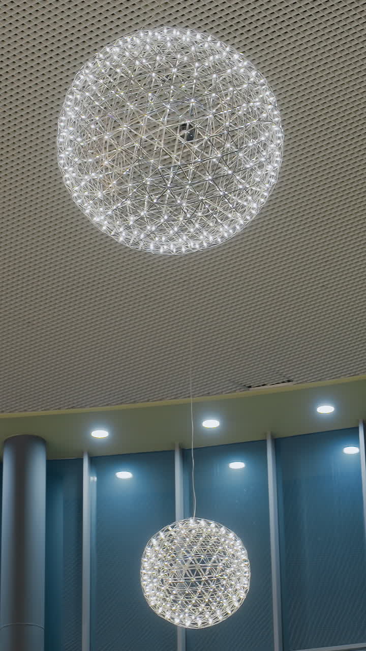 Smiling young woman taking a selfie in front of a beautifully decorated Christmas tree with glowing lights and colorful ornaments, capturing a festive holiday moment