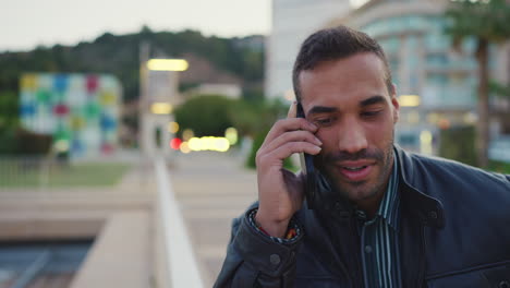 young man calling on smartphone outdoors.