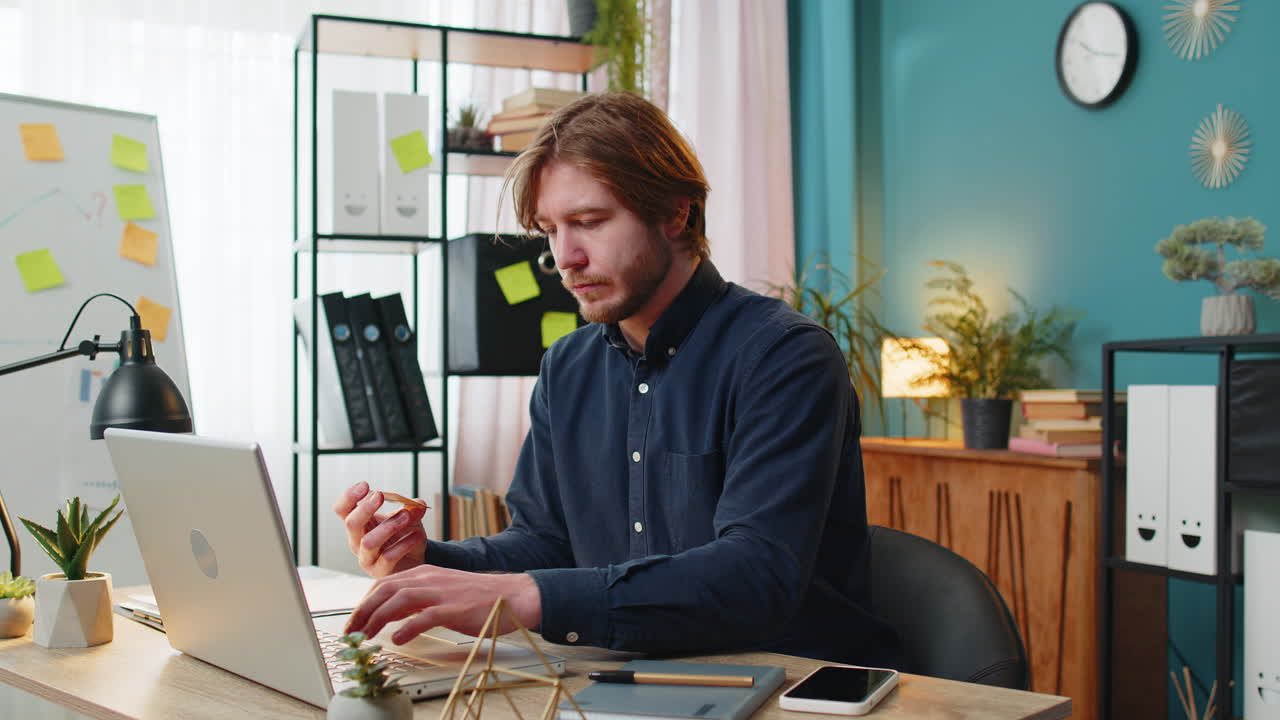 Glad forretningsmand, der bruger bankkreditkort og bærbar computer til online shopping betalinger på hjemmekontoret