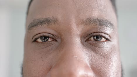 unaltered portrait of happy african american male doctor opening eyes and looking at camera