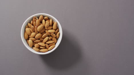 Video-of-fresh-fruit-almonds-in-a-bowl-on-grey-background